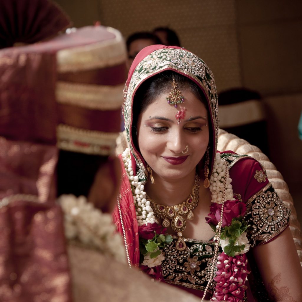 Shy smile of a bride in a Hindu wedding by kunjan detroja