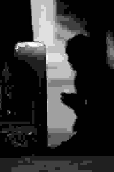 backlit silhouette of a monk praying