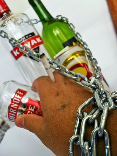 chain around bottles of alcohol and a hand